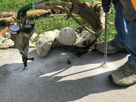 This Is A Picture Of The PolyLevel Process Of Concrete Lifting. Small Holes Are Drilled And Foam Is Pumped Under Sunken Concrete To Raise It Up.